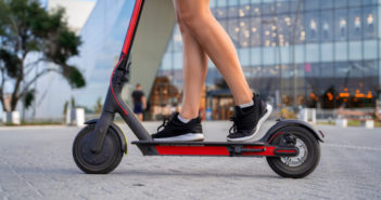 Closeup shot girls legs in sneakers on Electric push scooter