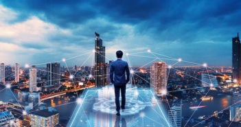 Business technology concept, Professional business man walking on future network city background and futuristic interface graphic at night, Cyberpunk color style